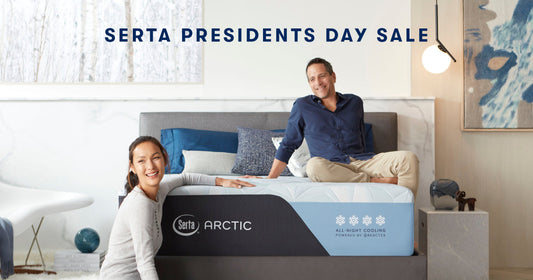 Couple sitting on Serta Arctic mattress smiling at the camera