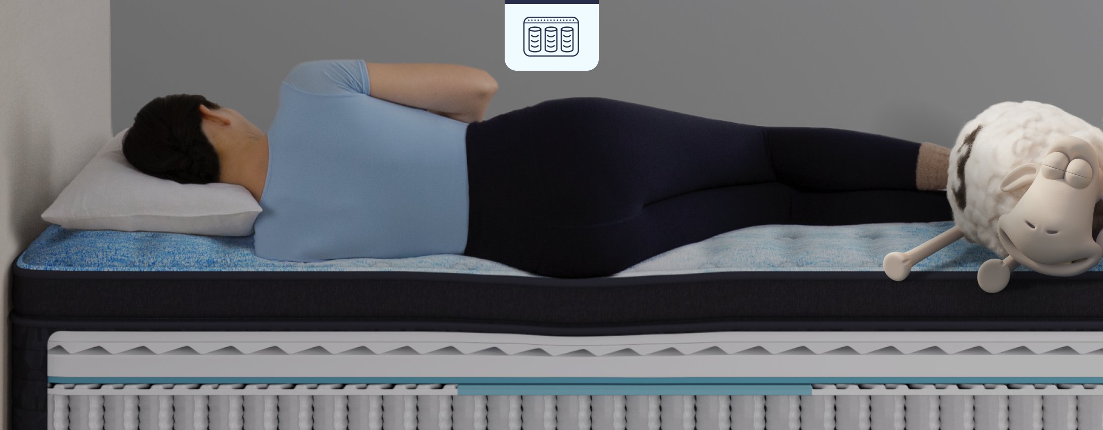 Person sleeping on their side on a Serta innerspring mattress with a cutaway view showing its coil support system, while a relaxed Serta sheep rests nearby.