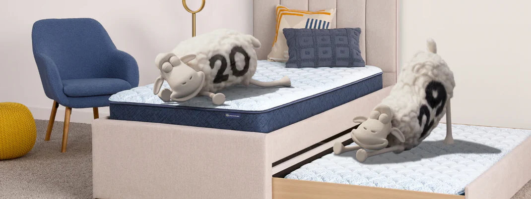 2 serta sheep lounging on a twin mattress with trundle bed.