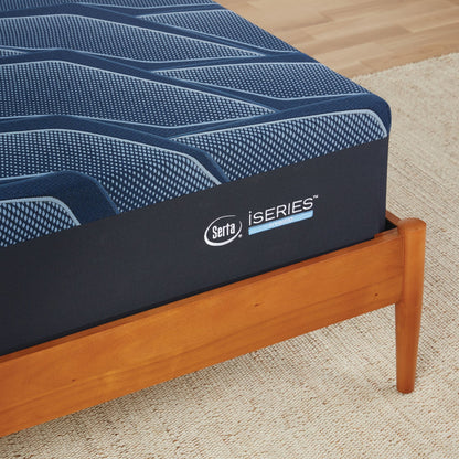 A corner of a wooden bed with a Serta iSeries medium blue mattress||feel: medium||level: standard