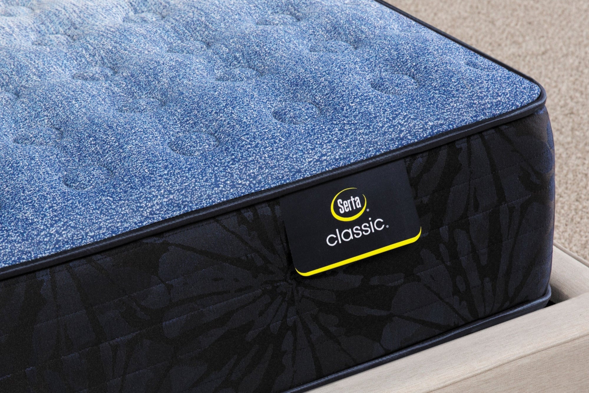 Close-up of a Serta Classic Firm mattress, featuring breathable materials, durable coils, and three-zone lower back support.