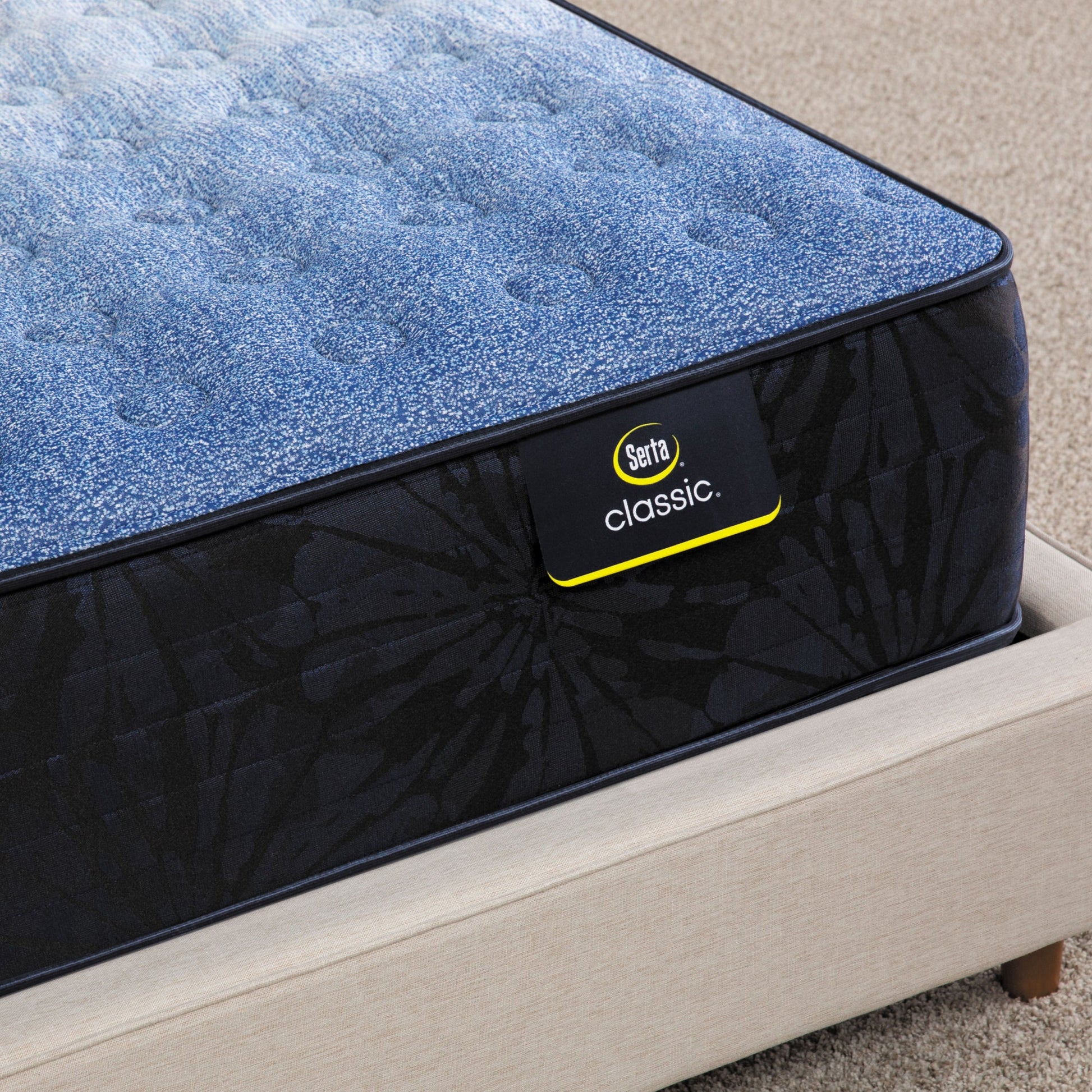 Corner of Serta classic brecon firm mattress sitting in a beige bed frame ||feel: firm ||level: enhanced