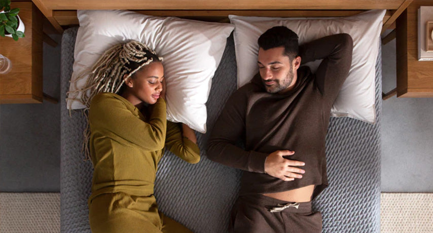 Couple sleeping on mattress