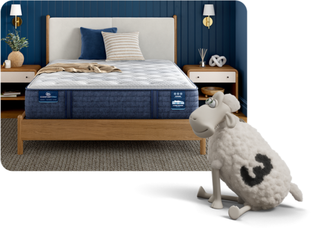 Serta iComfort Pro mattress on a bedroom in a serene blue bedroom decorated with a throw blanket and pillows. A Serta sheep overlays this image smiling.