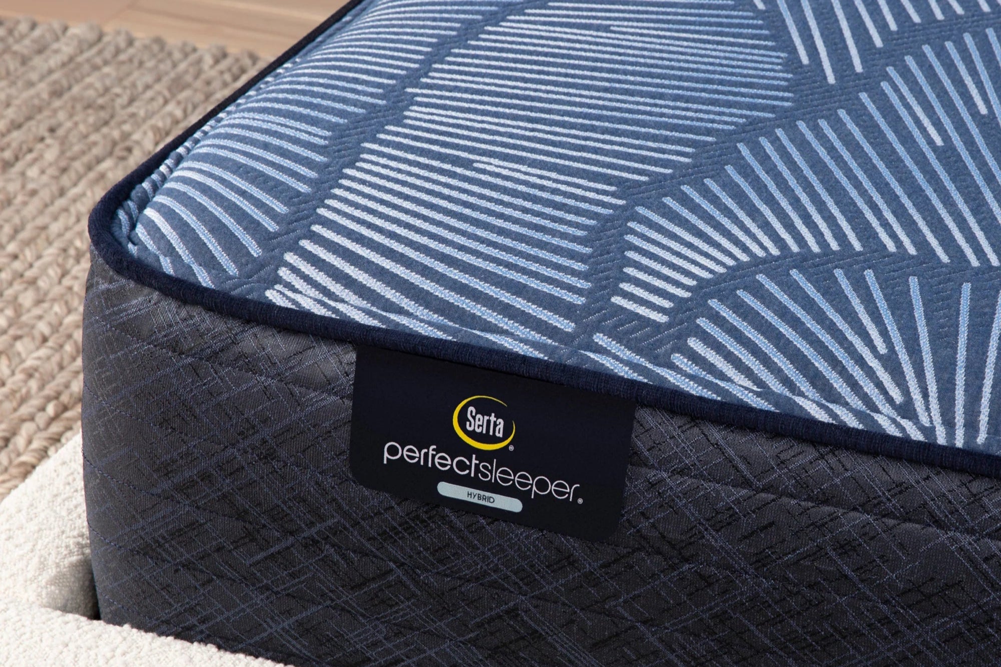 Close-up of a Serta Perfect Sleeper Hybrid Firm mattress, showcasing its smooth top design, cooling features, and supportive hybrid construction.