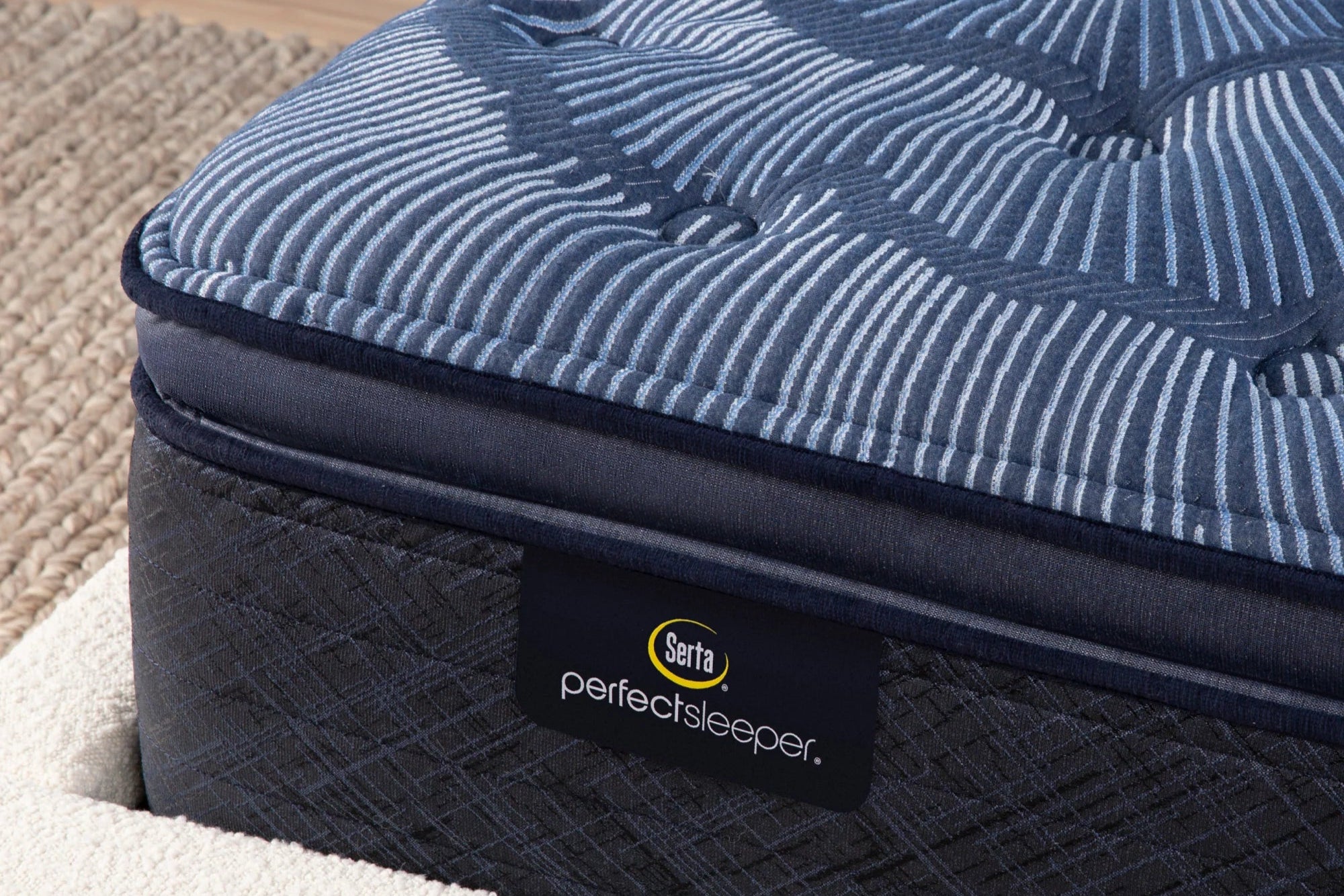 Close-up of a Serta Perfect Sleeper innerspring mattress with a plush pillow top, highlighting its cushioning and targeted support.