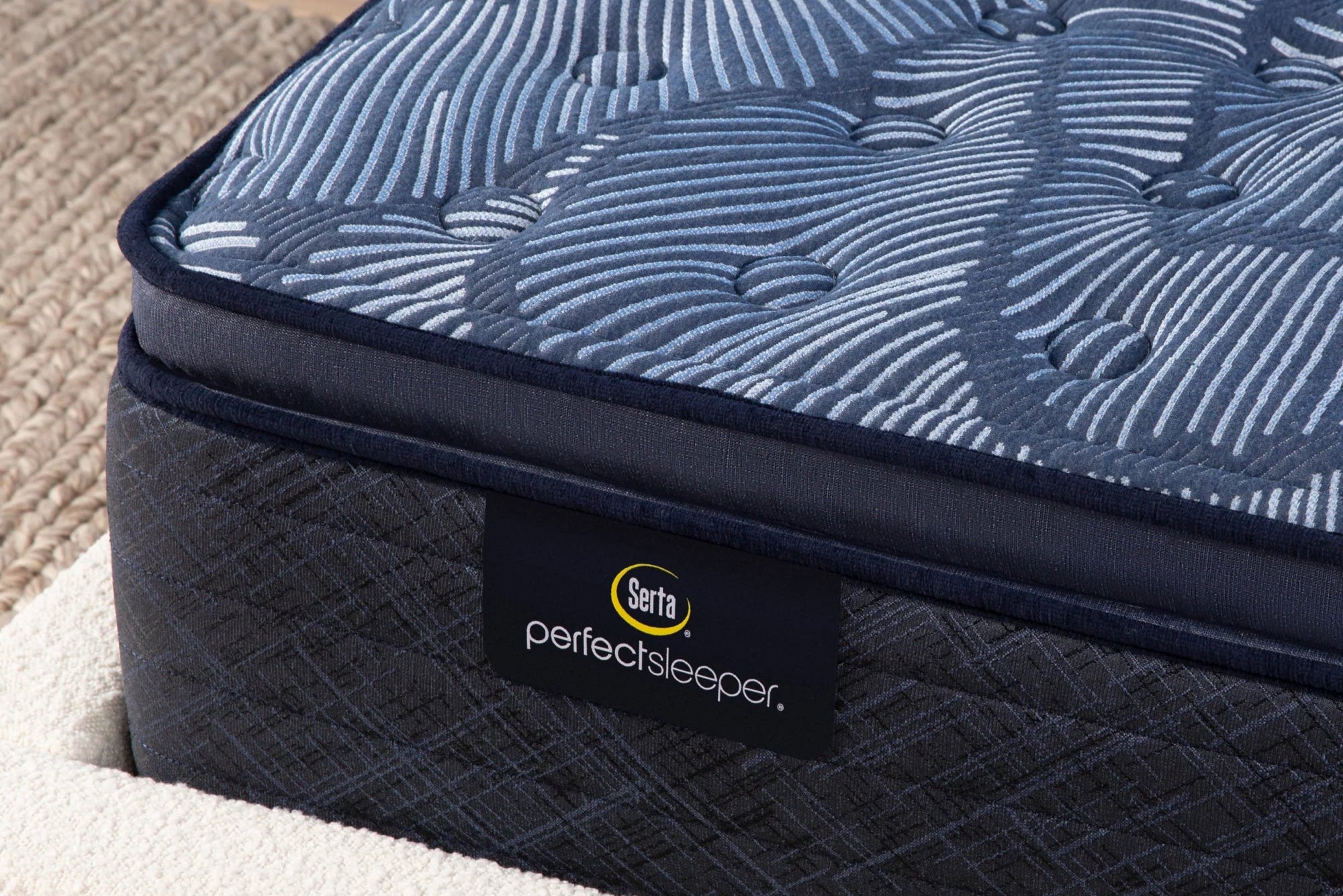 Close-up of a Serta Perfect Sleeper Innerspring Medium mattress with a plush pillow top, highlighting its antimicrobial technology, targeted support, and cooling upgrade.