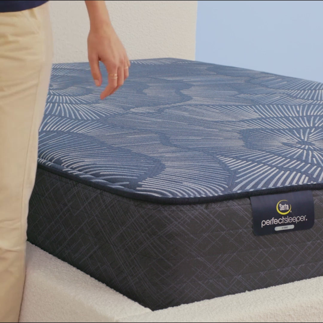 Person sitting on Serta Perfect Sleeper Hybrid firm mattress to show firmness||feel: firm||level: standard