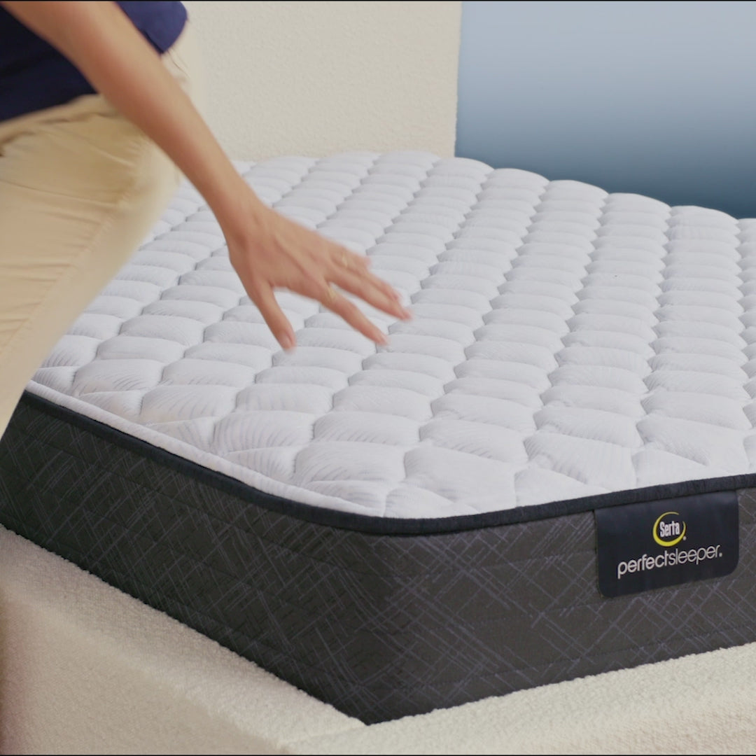 Person sitting on bed to show firmness level of Serta Perfect Sleeper firm mattress||feel: firm||level: standard